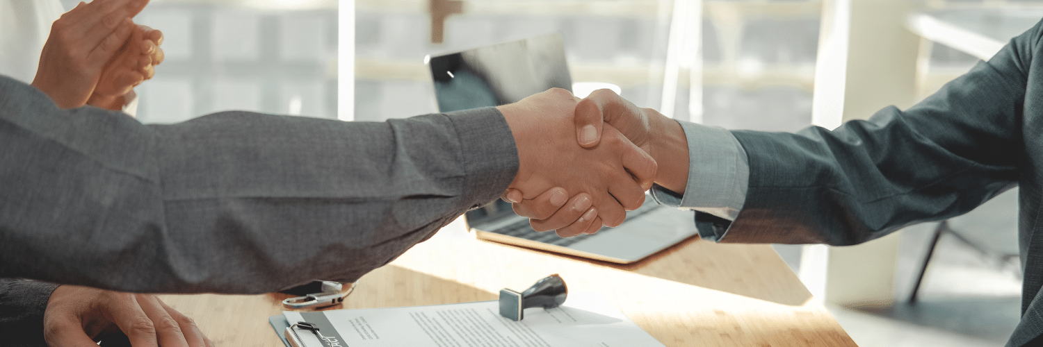 Two business people shaking hands, with one's hand holding a document titled 'Lease Agreement'